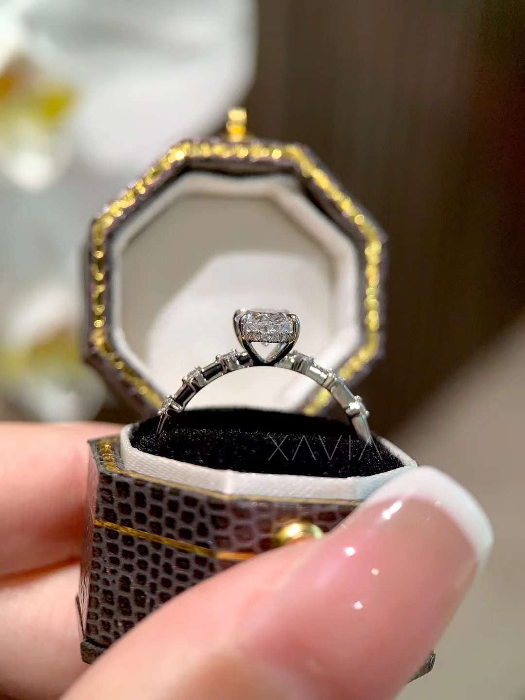oval cut lab grown diamond engagement ring with beaded side round stones worn on woman’s hand